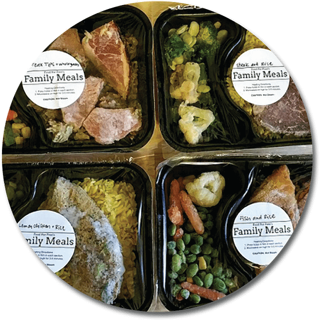 photo of four different meal combos each in black trays and each with a white round label on it